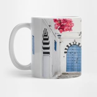 Alley with blue door and pink blossom in Tunisia Mug